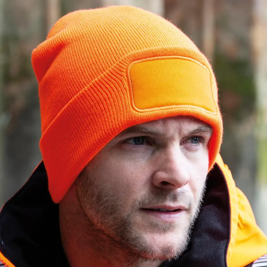 Czapka pomarańczowa fluoro na modelu.